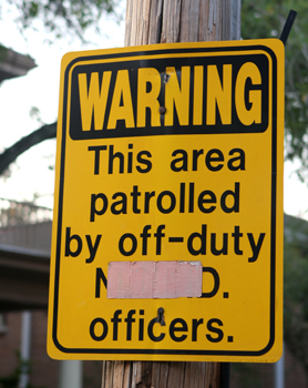 A sign announcing the presence of off-duty NOPD patrols in the Uptown area. (UptownMessenger.com file photo by Sabree Hill)