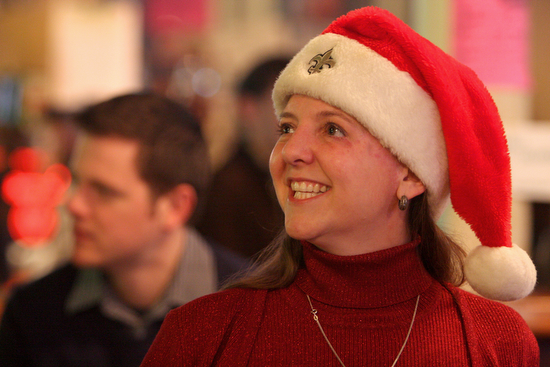 Kara Morgan, President of the Irish Channel, smiles while wearing a Saints-emblazoned Saints hat at the Irish Channel Neighborhood Association Christmas party at Tracey's bar in 2010, which included a toy drive in partnership with the New Orleans Police Department's Sixth District. (UptownMessenger.com file photo by Sabree Hill)