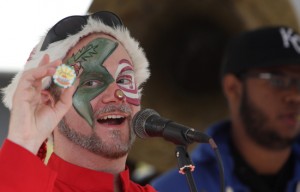 Announcer Andrew Ward holds up "Market Money" at the 2011 Freretstivus market on Freret Street. (UptownMessenger.com file photo by Sabree Hill)