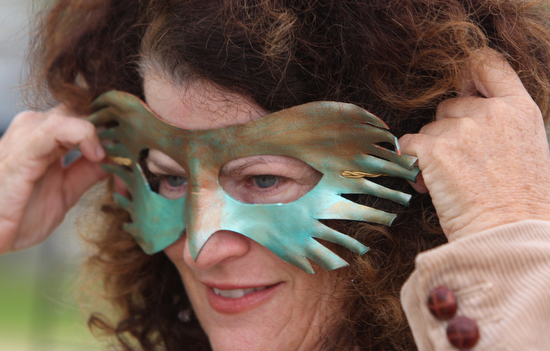 Helen Ball tries on a leather masquerade mask from Dante&#39;s Masquerade at the Arts Market. (Sabree Hill, UptownMessenger.com) - 00054