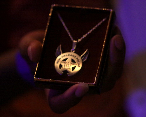 The silver pendant presented to Thomas' family is the NOPD star and crescent badge, engraved with Thomas' name and badge number, adorned with a pair of angel wings. (Robert Morris, UptownMessenger.com)