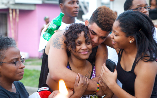 Parents of Londyn Samuels, Keion Reed and Andrea Samuels are comforted with hugs by friends between tears at the vigil. (Sabree Hill, UptownMessenger.com)