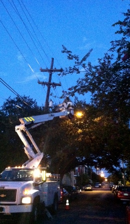 The Entergy bucket truck gamely repairs a broken power line inside a snarl of branches. (photo by Jean-Paul Villere for UptownMessenger.com)