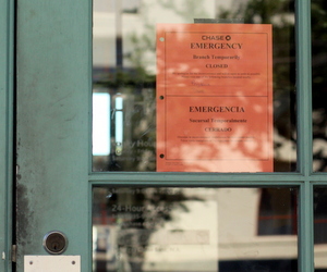 An "Emergency" sign in the door of the Chase Bank branch on St. Charles Avenue tells customers the bank is temporarily closed. (Robert Morris, UptownMessenger.com)