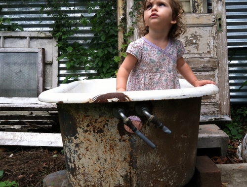 From December 2012, the youngest Villere daughter pauses at play inside a backyard clawfoot tub. (by Jean-Paul Villere for UptownMessenger.com)