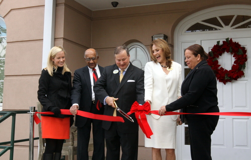 Poydras Home CEO Jay Rive cuts the ribbon at the entrance of the new Oak House building, surrounded by (from left) Lauren Hotard of Councilwoman Stacy Head's office, chaplain Roosevelt Stephens, board president Jill Winston and City Councilwoman Cynthia Hedge-Morrell. (Robert Morris, UptownMessenger.com)