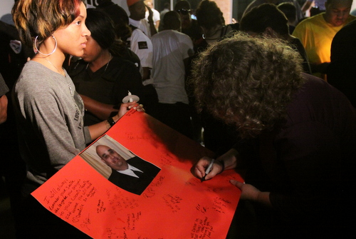 A supporter signs a poster in memory of Hector Trochez. (Robert Morris, UptownMessenger.com)