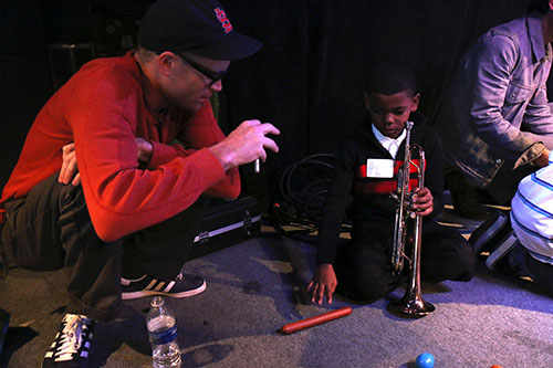 Little Big Horns' Trombonist Charlie Halloran (left) puts down his bone to give percussion instruction to Jacob Jones (right).
