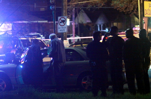 Investigators examine a sedan parked in the Claiborne Avenue neutral ground following a shooting Friday evening. (Robert Morris, UptownMessenger.com)