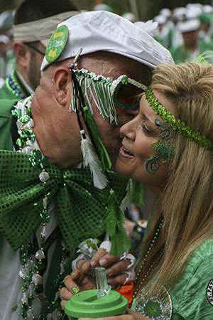 Dana Prados (right), receives a kiss on the cheek in exchange for a flower during Saturday's Irish Channel Parade.