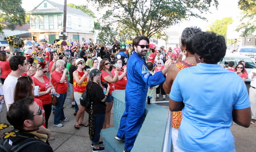 Kara Morgan's partner Trey Bornmann, clasps hands on the steps of the Lyons Center in front of a sea of her friends and supporters during a second line celebration of her life on Saturday. (Robert Morris, UptownMessenger.com)