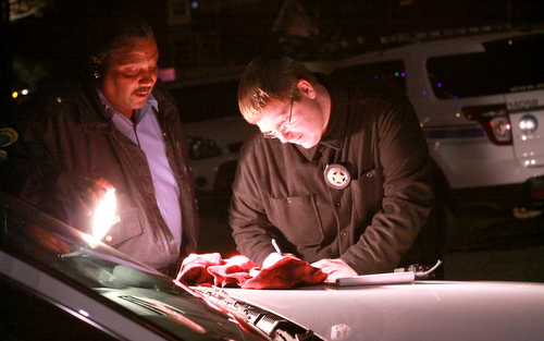 Police officers document a gun recovered during the manhunt near Cadiz and Loyola streets on Sunday, Jan. 4. (Robert Morris, UptownMessenger.com)