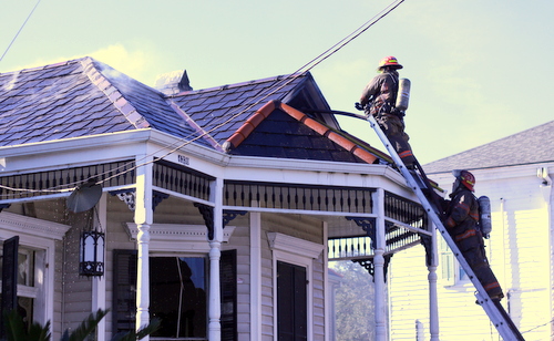Firefighters battle a blaze in the attic of a house at 4320 Constance Street on Thursday morning. (Robert Morris, UptownMessenger.com)