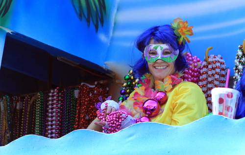 A member of the Krewe of Iris prepares to throw beads at the corner of St. Charles and Napoleon avenues. (Robert Morris, UptownMessenger.com)