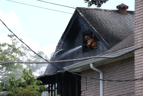 A firefighter battles the blaze at 5940 Freret Street. (Zach Brien for UptownMessenger.com)