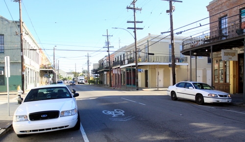Two police vehicles remain at the intersection of Magazine Street and St. Mary on Friday morning, following an overnight shooting there. (Robert Morris, UptownMessenger.com)