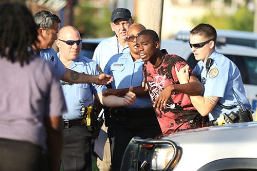 A visibly distraught man is pulled from the crime scene after rushing under the tape near the sight on a fatal shooting on Delachaise and South Robertson on Monday. The NOPD is currently investigating this shooting. (Zach Brien, UptownMessenger.com)