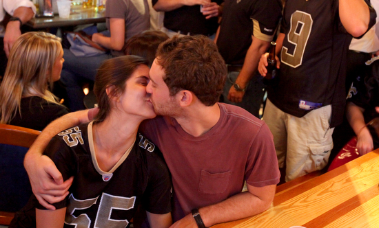 A couple kisses at a commercial break during the Saints season opener. (Sabree Hill, UptownMessenger.com)
