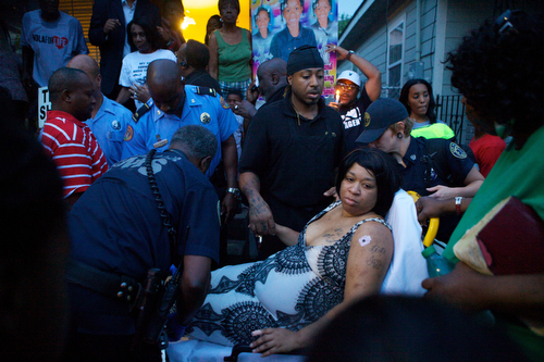 Ashley Moffet, mother of Arabian Gayles, is helped to an ambulance ambulance after fainting during the vigil.   (Sabree Hill, UptownMessenger.com)