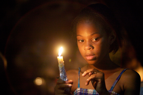 Amyri Alexander, 9, holds a candle for Arabian Gayles at the vigil. (Sabree Hill, UptownMessenger.com)