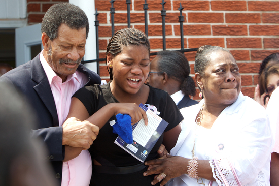 Sierra Gayles , sister of Arabian Gayles,  is supported up as she cries in pain while leaving her sisters funeral. (Sabree Hill, UptownMessenger.com)