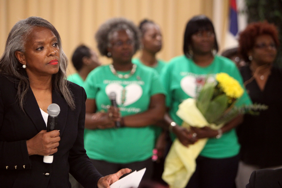 Rev. Pat Watson, executive director of Helping Mothers Heal, stands in front of a group of mothers during a ceremony Thursday evening.  (Sabree Hill, UptownMessenger.com)