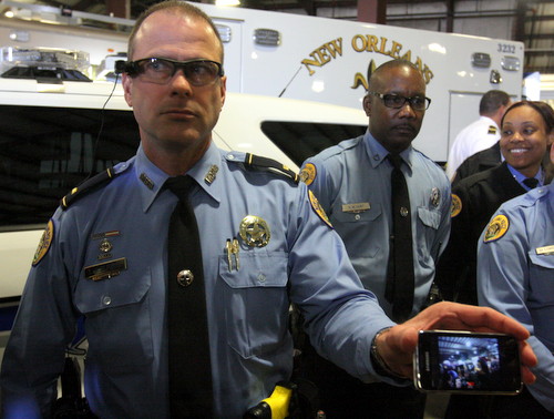 A police lieutenant demonstrates an extension of the body cameras that can be mounted on a visor or helmet. (Robert Morris, UptownMessenger.com)
