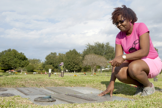 Linn James says a prayer to her son Christopher Guilbeau Jr. and tells him she loves him while visiting his grave in Avondale on Oct. 28, 2013. (Sabree Hill, UptownMessenger.com)