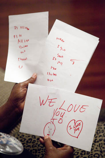 Cathy Rickmon holds notes that Lanny wrote in ICU unable to talk after being shot 13 times in February of 2013. One note asks if all the 13 bullets are out, another says I love you. (Sabree Hill, UptownMessenger.com) 
