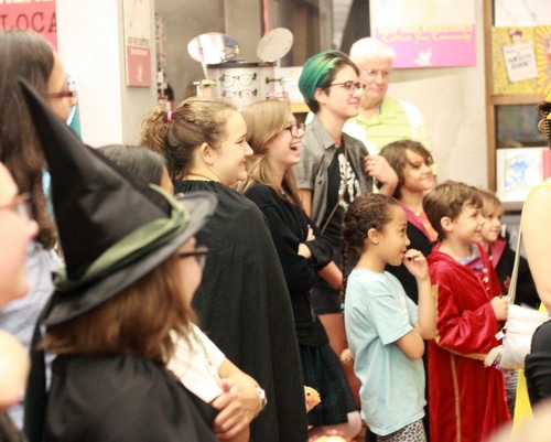 Clad in costume, Harry Potter fans laugh and listen to Frank Levy's story. (Robert Morris, UptownMessenger.com)